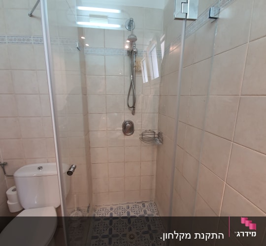 מקלחון זכוכית עם ראש מקלחת ומדף מתכת